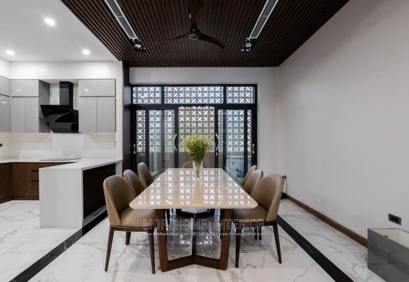 Thi công hoàn thiện nội thất phòng ăn biệt thự 4 tầng tại Nghệ An với bộ bàn ghế ăn hiện đại sang trọng. Bàn ăn mặt đá chân gỗ tự nhiên kết hợp với bộ 6 ghế ăn gỗ óc chó bọc da cao cấp.